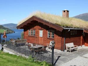 Cabaña de madera pequeña con techo de hierba en Four-Bedroom Holiday home in Olden 1, en Olden