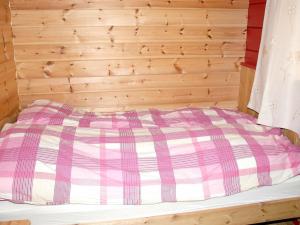 a bed in a room with a wooden wall at Three-Bedroom Holiday home in Isfjorden in Torvik