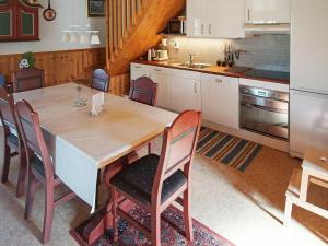 een keuken met een grote houten tafel en stoelen bij 6 person holiday home in TORSBY in Överbyn
