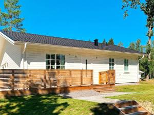 una casa con una valla de madera delante de ella en Holiday home FIGEHOLM III, en Figeholm