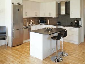 una cocina con armarios blancos y electrodomésticos de acero inoxidable en Holiday home FIGEHOLM III, en Figeholm