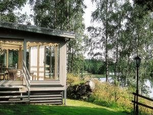 un porche cubierto de una casa con porche en Four-Bedroom Holiday home in Åtvidaberg, en Yxnerum