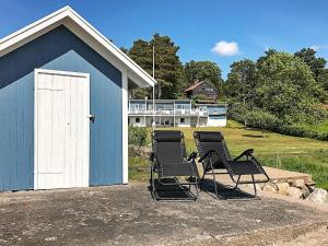 two chairs sitting in front of a blue building at 8 person holiday home in LJUNGSKILE in Ljungskile