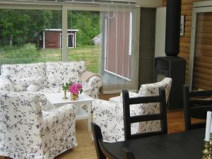 a living room with a couch and chairs and a stove at Four-Bedroom Holiday home in Åtvidaberg in Yxnerum