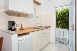 a kitchen with white cabinets and a sink and a window at Betty Apartments in Drios