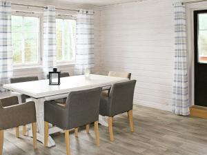 a dining room with a white table and chairs at 27 person holiday home in dyrdal in Frafjord