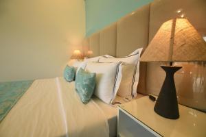 een slaapkamer met een bed met een lamp en kussens bij Tip Top Boutique hotel in Ella