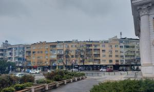 a large building with cars parked in a parking lot at Apartment Emilija in Skopje