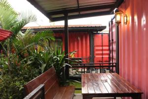 een houten bank op een patio met planten bij Amazon Resort in Suratthani