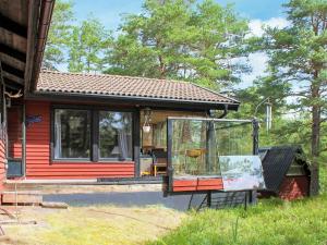 una pequeña casa roja con una ventana delante en 7 person holiday home in LIDK PING en Lidköping