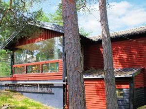 una casa rossa con alberi di fronte di 7 person holiday home in LIDK PING a Lidköping