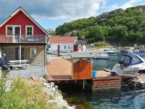 a dock with a house and a boat in the water at 4 person holiday home in Urangsv g in Ervik