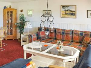 ein Wohnzimmer mit einem Sofa und einem Tisch in der Unterkunft One-Bedroom Holiday home in Hästveda in Lur
