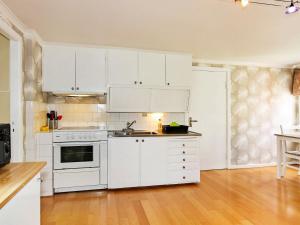 cocina con electrodomésticos blancos y suelo de madera en 4 person holiday home in S DER KRA, en Söderåkra