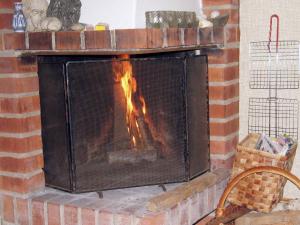 a brick fireplace with a fire in it at 6 person holiday home in FALKENBERG in Falkenberg