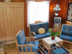sala de estar con muebles azules y TV en Two-Bedroom Holiday home in Utvik 1, en Sølberg
