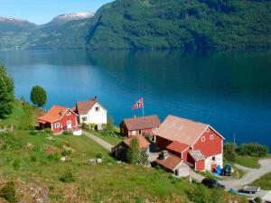 a group of houses on a hill next to a lake at Two-Bedroom Holiday home in Utvik 1 in Sølberg