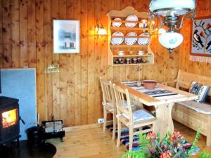 a dining room with a table and a stove at Two-Bedroom Holiday home in Utvik 1 in Sølberg