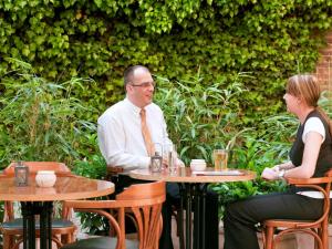 a man and woman sitting at tables in a restaurant at ibis Aachen Marschiertor - Aix-la-Chapelle in Aachen