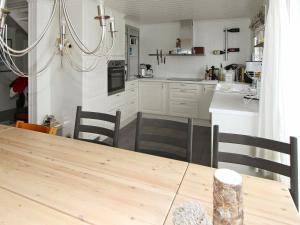 a kitchen with a wooden table and a dining room at 10 person holiday home in SERAL in Åseral