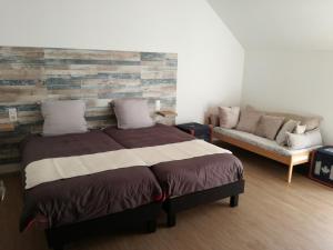 a bedroom with a bed and a couch at Atypiques Confitures, Chambres d'Hôtes in Couffy