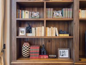 a book shelf with books and pictures on it at Sofitel Legend Santa Clara Cartagena in Cartagena de Indias