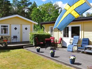 una casa y un patio con mesa y sillas en Holiday home Mönsterås V, en Mönsterås