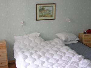 a white bed in a bedroom with a picture on the wall at 6 person holiday home in H CKSVIK in Håcksvik
