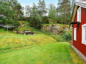 un patio con una mesa de picnic y una casa roja en 4 person holiday home in HEN N, en Nösund