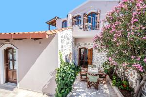 a house with flowers on the side of it at Elia Woodstone Houses in Elaía +73 photos