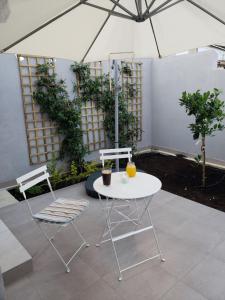 une table blanche, deux chaises et un parasol dans l'établissement Modern & Cozy Studio w/ Backyard Near City Center, à Limassol