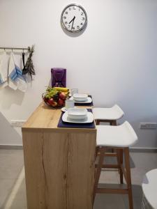 a kitchen with a table with a clock on the wall at Modern & Cozy Studio w/ Backyard Near City Center in Limassol