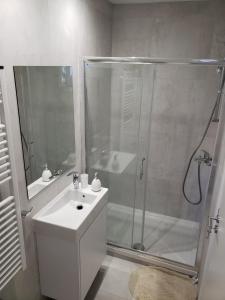 a white bathroom with a shower and a sink at Modern & Cozy Studio w/ Backyard Near City Center in Limassol
