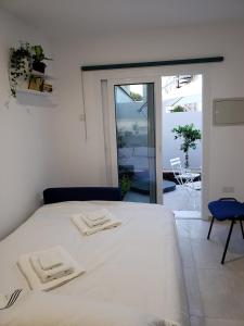 a bedroom with a white bed with two towels on it at Modern & Cozy Studio w/ Backyard Near City Center in Limassol
