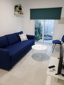 a living room with a blue couch and a table at Modern & Cozy Studio w/ Backyard Near City Center in Limassol