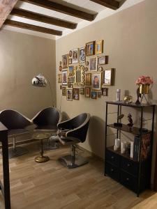 Appartamento Frida في بارما: غرفة بها كرسي وطاولة وصور على الحائط