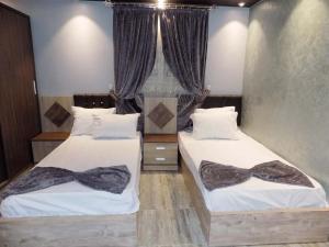 1 dormitorio con 2 camas con corbatas de lazo en City Hotel en El Cairo