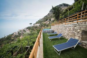 dwa niebieskie fotele siedzące na szczycie wzgórza w obiekcie San Giacomo Relais w mieście Furore