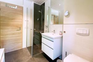 ein Badezimmer mit einem weißen Waschbecken und einer Dusche in der Unterkunft Gronenberger Mühle Haus 1 in Scharbeutz