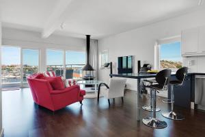 uma sala de estar com uma cadeira vermelha e uma mesa em Hotell Kungshamn Suites em Kungshamn
