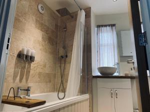 uma casa de banho com um chuveiro, uma banheira e um lavatório. em The Stowe em Shrewsbury