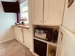 eine Küche mit einer schwarzen Mikrowelle in einem Schrank in der Unterkunft The Stowe in Shrewsbury
