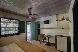 a bedroom with a bed and a table with a chair at Villa Buonabitacolo in São João del Rei