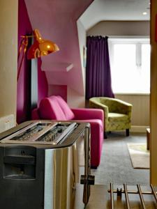 a living room with a pink couch and a table at Bryn Melyn Apartments in Barmouth