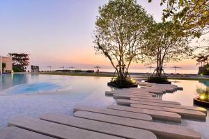 a pool with trees in the middle of it at Veranda Residence Pattaya by One in Na Jomtien