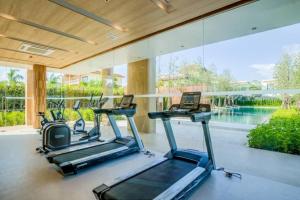 a gym with cardio machines and a large window at Veranda Residence Pattaya by One in Na Jomtien
