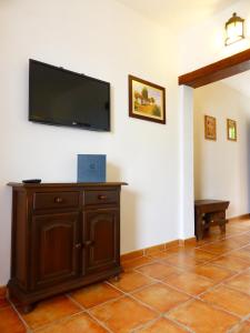 sala de estar con TV de pantalla plana en la pared en Hotel Rural El Navío - Adults Only, en Alcalá