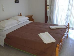 - un grand lit avec 2 serviettes dans l'établissement Anatoli Apartments, à Agios Stefanos