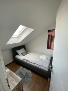 a small bedroom with a bed with a skylight at APARTMAN PAVIĆ in Vinkovci