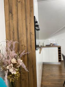 a vase of flowers sitting next to a door at APARTMAN PAVIĆ in Vinkovci